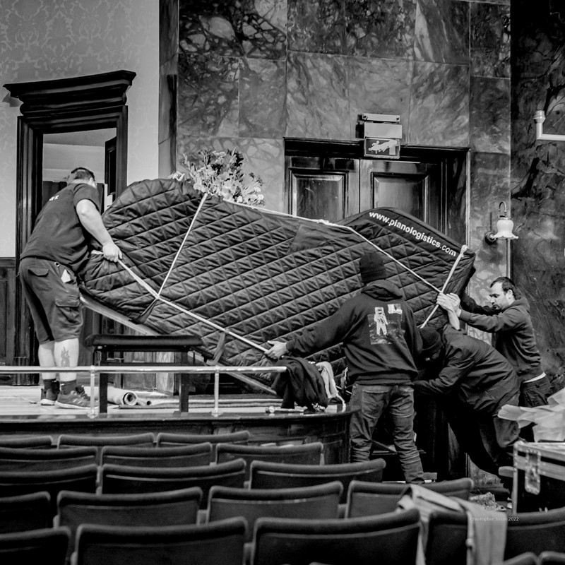 Technicians moving a Yamaha piano off stage from Alexandre Tharaud’s lunchtime piano recital in October 2021 directly before the next piano comes on stage for Seong-Jin Cho’s rehearsal.