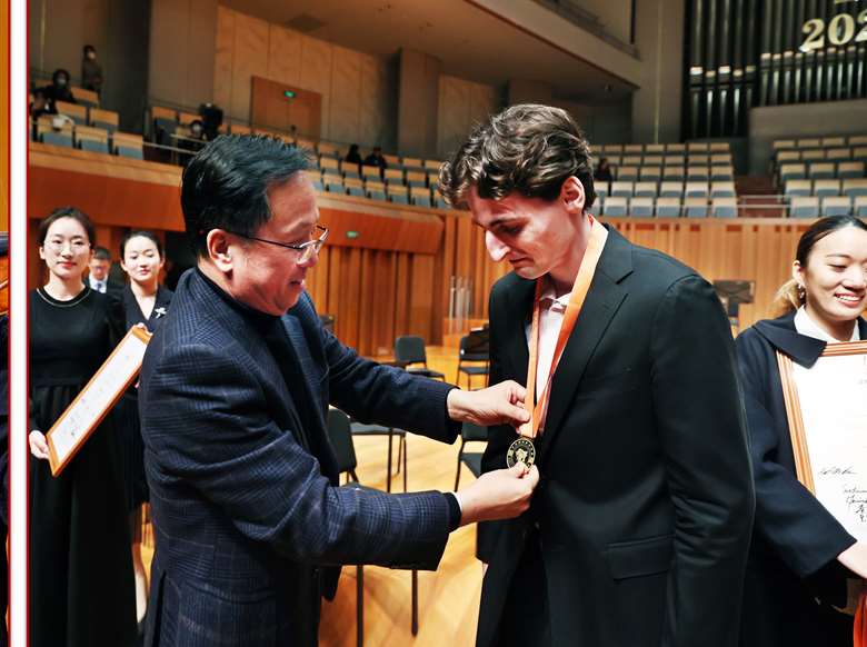 Joshua Brown receives the Gold Medal from Liguang Wang, founder of Global Music Education League and the Competition